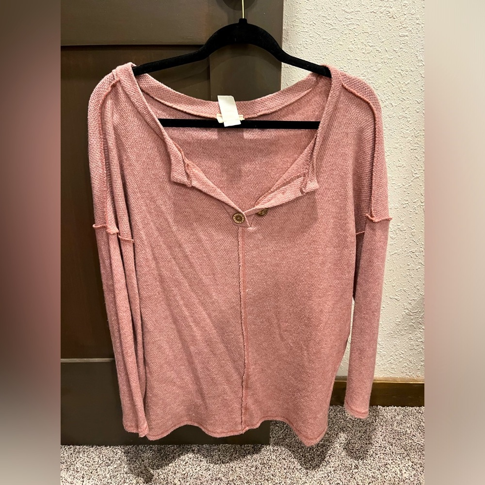Light pink wide neck v shirt. Buttons are not functional. Soft material.